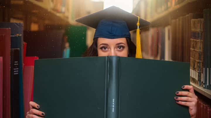 Student hidden behind book, looking prepared