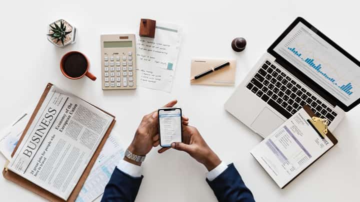 Calculator, laptop and man holding a mobile device