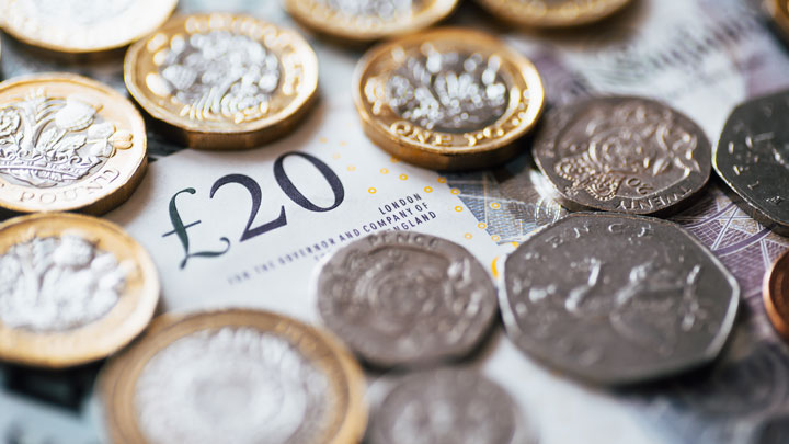 Money - coins and a 20 pound note in pile