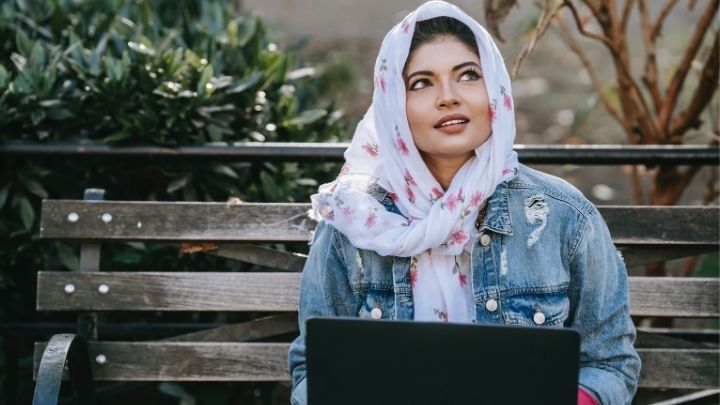 A lady working on a laptop looking up to the sky