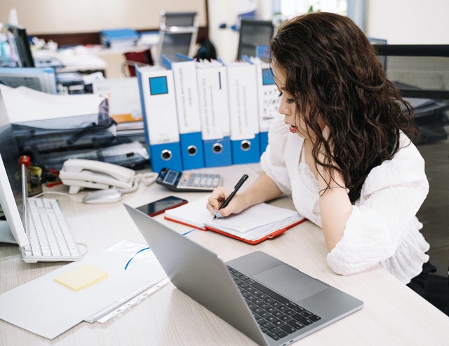 A lady making notes at a desk