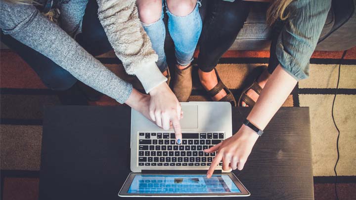 Hands pointing to a laptop screen