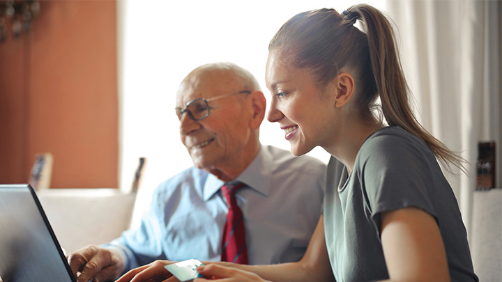 two people looking working at a laptop