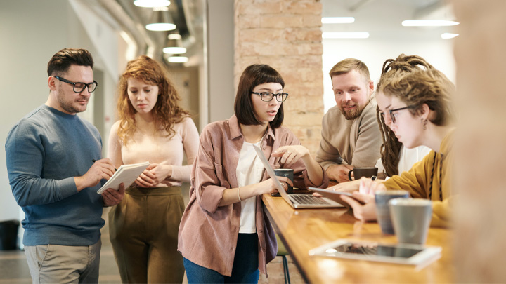 People standing in an office looking at tablet computers