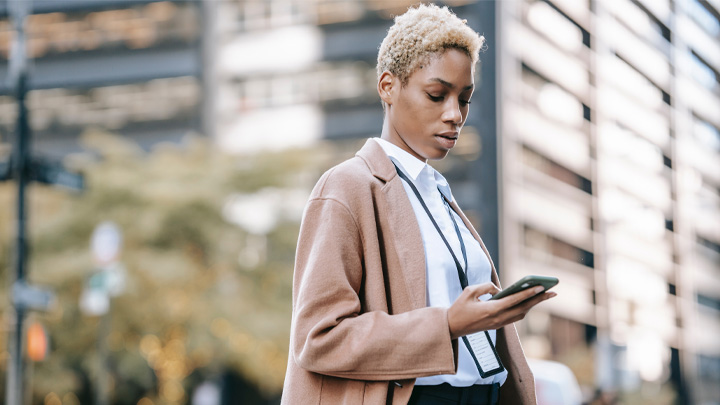 Woman in street looking at her mobile phone