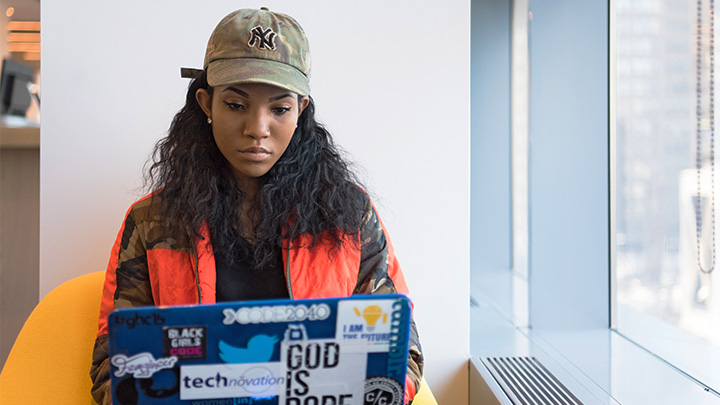 Women in cap working on laptop