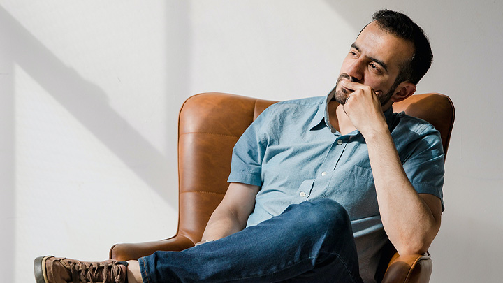 Man sat back in armchair, contemplating something