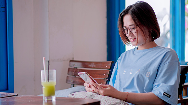 Woman sat at table looking at mobile phone