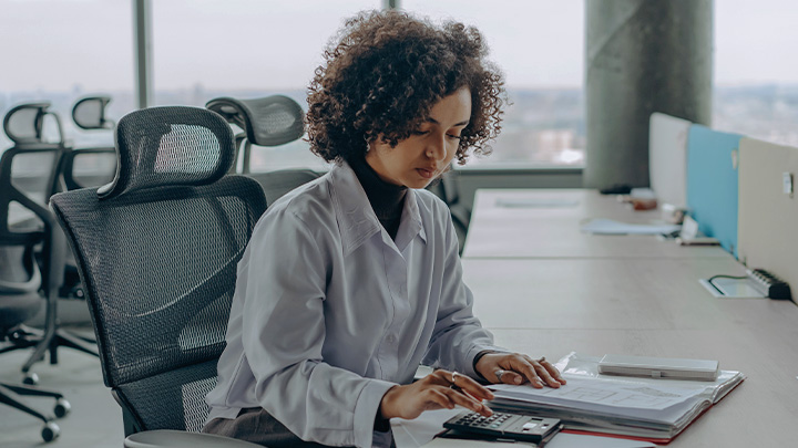 Woman working at desk with calculator