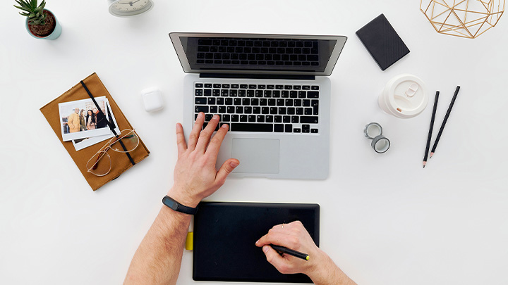 Picture above a laptop with a person's hands on it