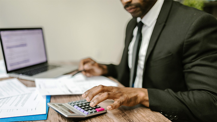 Man working at desk using calculator