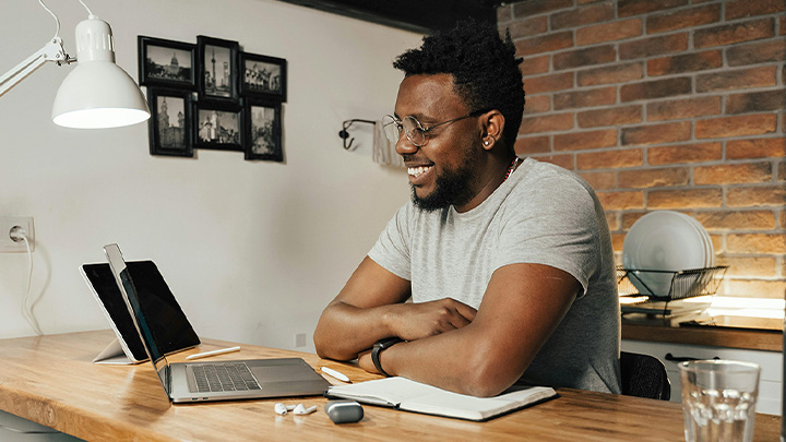 map smiling at laptop