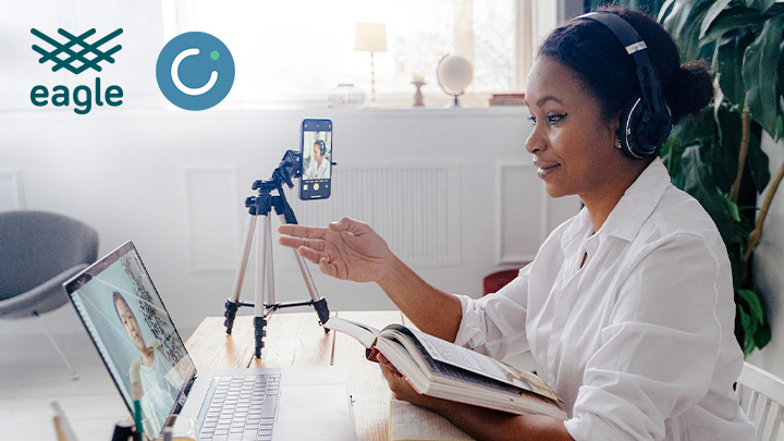 woman at desk with mobile phone recording her