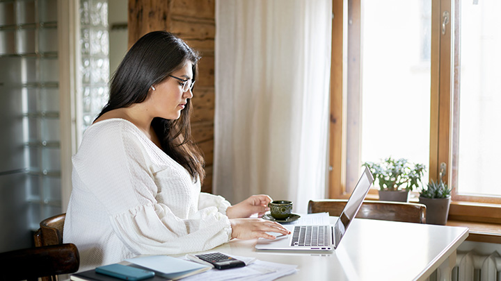 Woman at home, working on laptop
